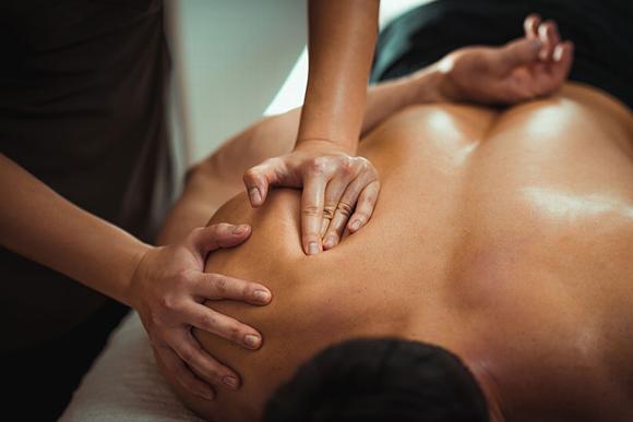 man having muscle relaxing sports massage on shoulder